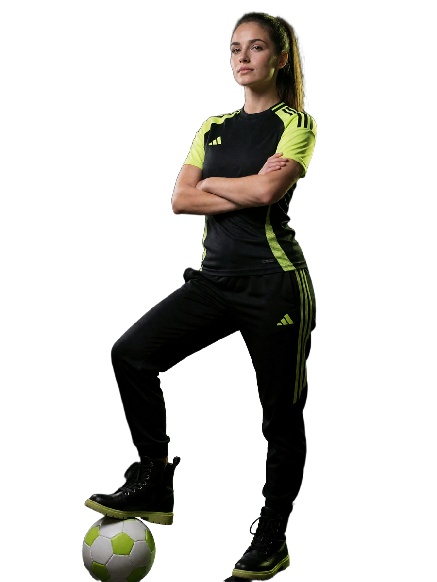 Spielerin in schwarz-limefarbenem Trikot mit Ball vor Torwand im Flutlicht - Symbolbild f&uuml;r den Online Casino Bonus bei Zoccer